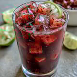 Vibrant dragon fruit and strawberry refresher with creamy coconut milk, served over ice in a tall glass.