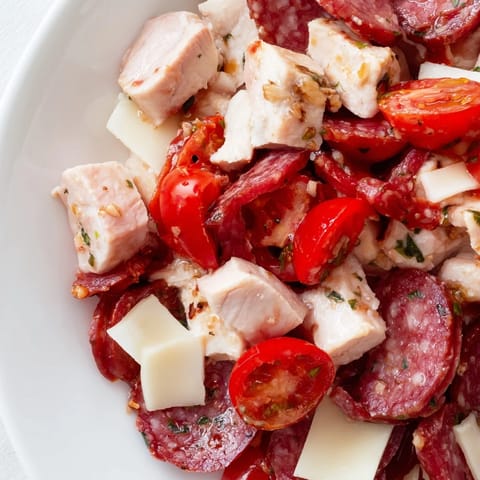 Freshly chopped Italian Deli Chopped Chicken Salad with colorful romaine, cherry tomatoes, and red onion in a bright bowl.  