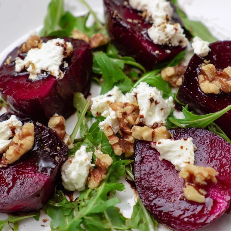 Vibrant Roasted Beet Goat Cheese Salad served on a rustic wooden table, featuring jewel-toned beets, fresh greens, and golden walnuts for a beautiful presentation.
