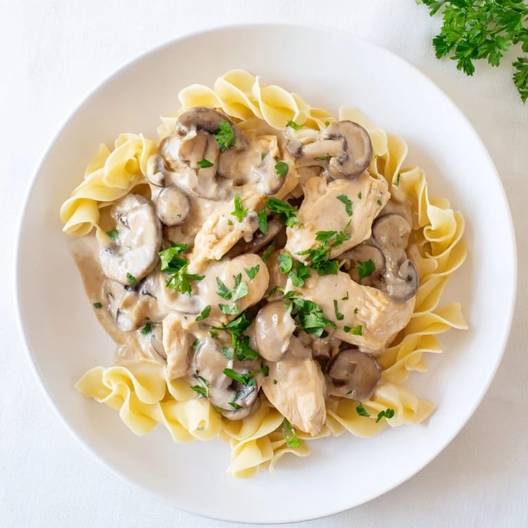 Savory Chicken and Mushroom Stroganoff with tender meat and earthy mushrooms on a bed of noodles.
